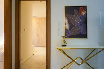 a hallway with a table and a painting on the wall at Millennium Binghatti Residence 2BR Burj Khalifa and Lake in Dubai