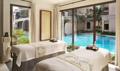 two beds in a room with a swimming pool at Luxury Holiday Home, Spacious 1 bedroom, Burj Alarab full ocean view, located in Anantara the palm, Palm Jumeirah, Dubai in Dubai