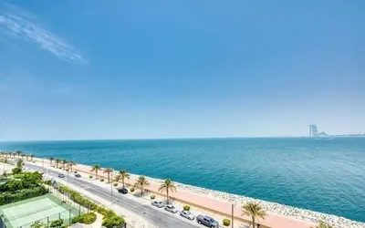 a road next to the ocean with a tennis court at Luxury Holiday Home, Spacious 1 bedroom, Burj Alarab full ocean view, located in Anantara the palm, Palm Jumeirah, Dubai in Dubai