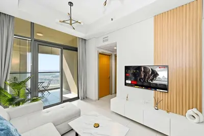 a living room with a tv on a wall at Brand new Business Bay location in Dubai