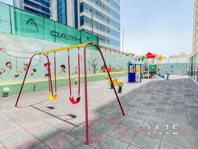 a playground in a city with a play area at Rare Holiday Homes - Near City Center Ma'eisem - Pool view - Crescent Tower A - R706 - IMPZ in Dubai