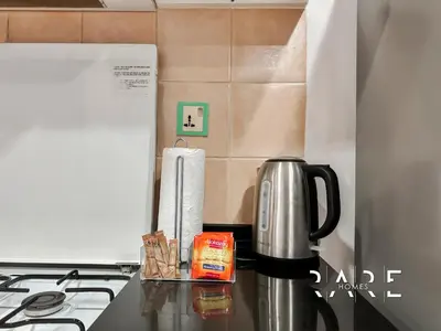 a coffee maker on a counter next to a stove at Rare Holiday Homes - Near City Center Ma'eisem - Pool view - Crescent Tower A - R706 - IMPZ in Dubai