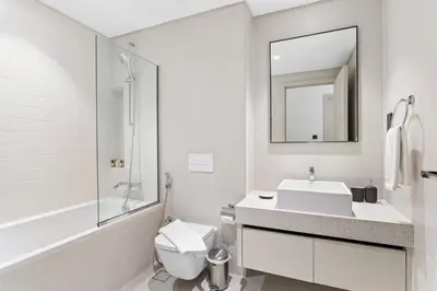 a bathroom with a sink and a toilet and a mirror at Silkhaus Marina View 1BDR Marina Vista Tower in Dubai