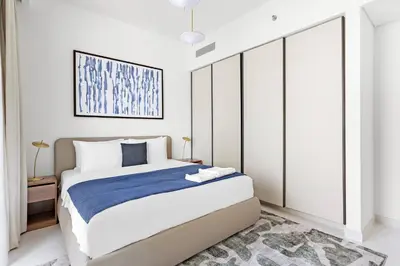 a bedroom with a large bed with a blue blanket at Silkhaus Mid Floor Marina Vista with Private Beach in Dubai
