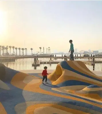 two children standing on a skateboard ramp at a skate park at Contemporary 1BR condo with pool at Creek Harbour in Dubai