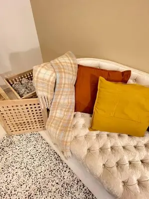 a white couch with a blanket and a yellow pillow at Contemporary 1BR condo with pool at Creek Harbour in Dubai