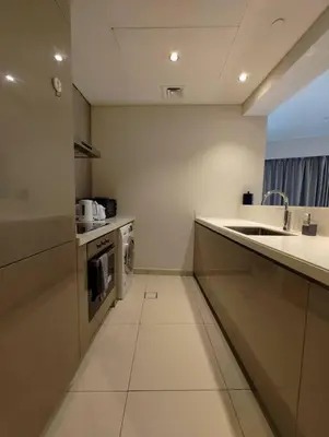 a white kitchen with a sink and a stove at 2BR Tower D Paramount Apartment in Dubai