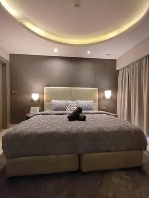 a teddy bear laying on a bed in a bedroom at 2BR Tower D Paramount Apartment in Dubai