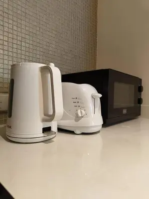 a white toaster sitting next to a microwave at 2BR Tower D Paramount Apartment in Dubai