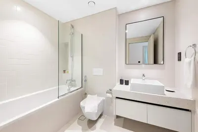 a bathroom with a sink and a toilet and a mirror at Silkhaus 1BDR with Private Beach Marina Vista in Dubai