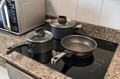 two pots sitting on top of a stove in a kitchen at 2BR Torch Tower High Floor Dubai Marina in Dubai