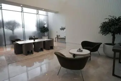 a living room with chairs and a table and a room with windows at 3BR Burj Khalifa Fountain Views Forte 1- 18th floor in Dubai