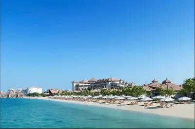 a beach with chairs and umbrellas and the ocean at AWS Holiday Homes - Oasis in the Palm in Dubai