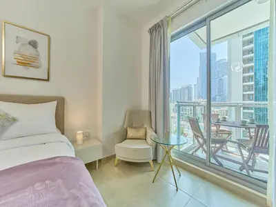 a bedroom with a bed and a balcony with a table and chairs at Golden homes Residences Tower 05 1BR CITY VIEW Near Dubai mall & burj khalifa in Dubai