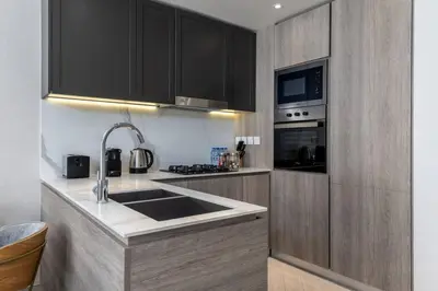 a kitchen with a sink and a stove top oven at Waves - Tranquil Living 2BR Apt in JVC with City Views in Dubai