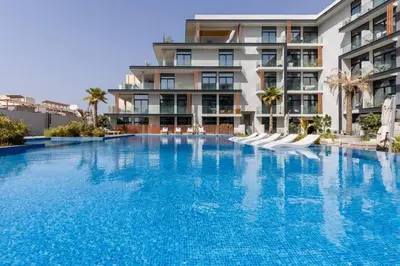 a large swimming pool in front of a building at Waves - Tranquil Living 2BR Apt in JVC with City Views in Dubai