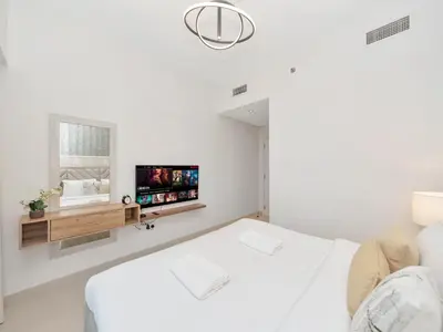 a white room with a bed and a tv at 2BR Burj Khalifa & Fountain Views Burj Crown 39th Floor in Dubai