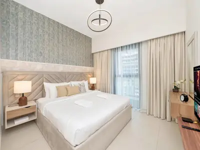 a bedroom with a large white bed and a television at 2BR Burj Khalifa & Fountain Views Burj Crown 39th Floor in Dubai