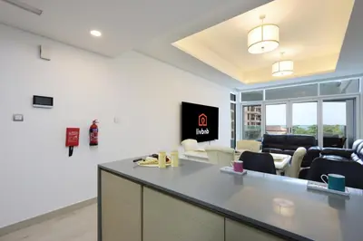 a kitchen and living room with a counter and chairs at Livbnb-Tranquil 1B Steps to PalmBoardwalk Sea View in Dubai