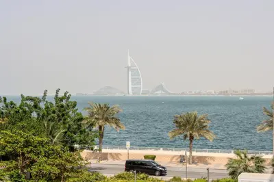 a car parked next to the water with a view of the city at Livbnb-Tranquil 1B Steps to PalmBoardwalk Sea View in Dubai