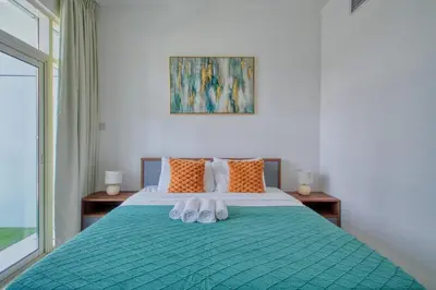 a bedroom with a bed with two white shoes on it at Aesthetic 2BR with Marina Waterfront View in Dubai