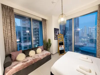 a living room with a couch and a large window at Panoramic Full Fountain,Opera& burj Sky View 4BR APT in Dubai