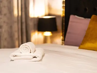 a pile of white towels sitting on a bed at Panoramic Full Fountain,Opera& burj Sky View 4BR APT in Dubai