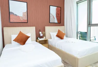 two beds in a room with white sheets and orange pillows at Stunning 2 Bedroom Apartment Downtown Views 2 - Tower 3 Downtown Dubai in Dubai