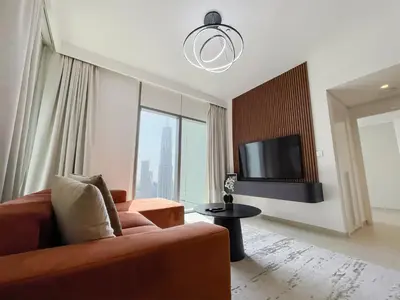 a living room with a couch and a flat screen tv at Stunning 2 Bedroom Apartment Downtown Views 2 - Tower 3 Downtown Dubai in Dubai