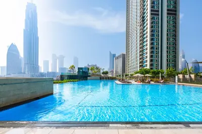 a large swimming pool in a city with tall buildings at Exclusive front row seats to Burj Khalifa fireworks from penthouse level, downtown Dubai in Dubai