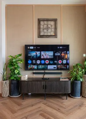 a living room with a large tv and two potted plants at Exclusive front row seats to Burj Khalifa fireworks from penthouse level, downtown Dubai in Dubai