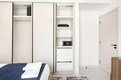 a bedroom with white closets and a bed at Silkhaus Palm View in Marina Vista Private Beach in Dubai