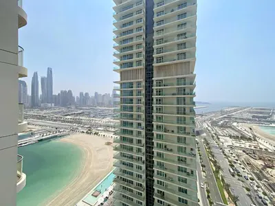 a tall building next to a beach and the ocean at Silkhaus Palm View in Marina Vista Private Beach in Dubai