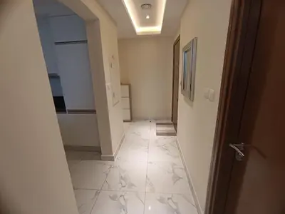 a hallway with a white tile floor and a door at Al Quoz 2 Bed Budget Apartment in Dubai