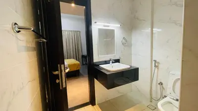 a bathroom with a sink and a toilet and a mirror at Ista Vacation Homes Rental LLC KARAMA in Dubai
