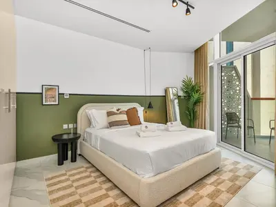 a bedroom with a large bed and a balcony at Sukoon's Waterfront Two-Bedroom in Dubai