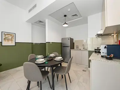 a dining room with a table and chairs in a kitchen at Sukoon's Waterfront Two-Bedroom in Dubai