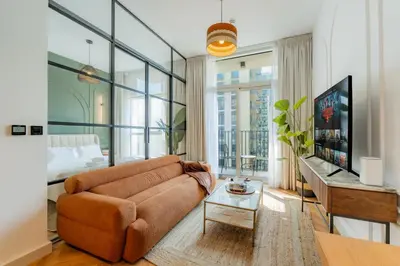 a living room with a couch and a tv at Elite Escapes - Socio Stylish 1 BHK Getaway in Dubai