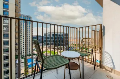 a balcony with a table and chairs and a view of a city at Elite Escapes - Socio Stylish 1 BHK Getaway in Dubai