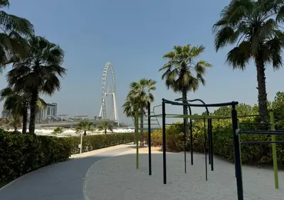 a playground with palm trees and a ferris wheel in the background at Premium Stay at The Address Residences JBR in Dubai
