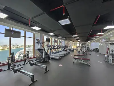 a gym with treadmills and machines in a building at Silkhaus Beach Accessible Studio Palm View in Dubai
