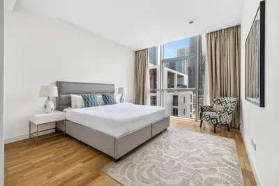 a white bedroom with a bed and a large window at 2BR plus M with Huge Balcony City Walk Building 22 in Dubai