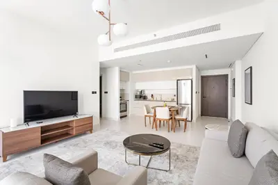 a living room with a couch and a tv at Silkhaus 1BDR with Private Beach Skyline Views in Dubai