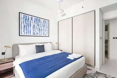 a bedroom with a large bed with a blue blanket at Silkhaus 1BDR with Private Beach Skyline Views in Dubai