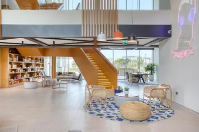 a staircase in a lobby with chairs and a table at Blueground Dubai Hills Estate balcony elev DXB-1120 in Dubai