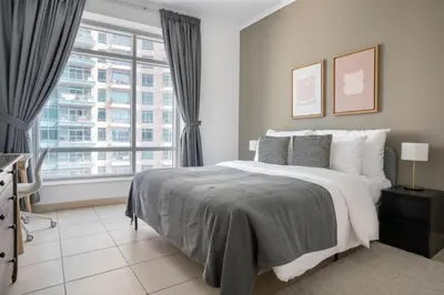 a bedroom with a large bed and a large window at Blueground Burj Views A sauna game room DXB-1386 in Dubai
