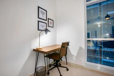 a desk with a lamp and a chair next to a window at Blueground Sheikh Zayed Rd pool gym DXB-545 in Dubai