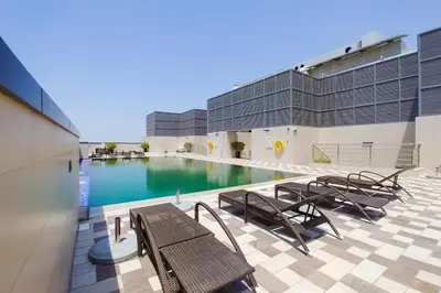 a swimming pool in a building with tables and chairs at Blueground Sheikh Zayed Rd pool gym DXB-545 in Dubai