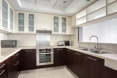 a kitchen with wooden cabinets and a sink at Blueground Boulevard Central pool gym DXB-1179 in Dubai