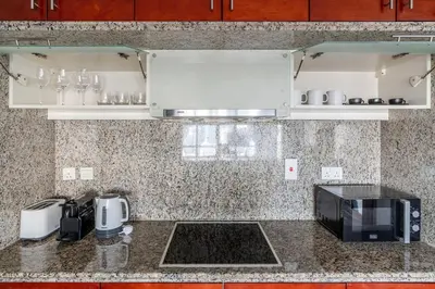 a kitchen counter with a microwave and a sink at Blueground South Ridge Tower 1 city view pool DXB-1409 in Dubai